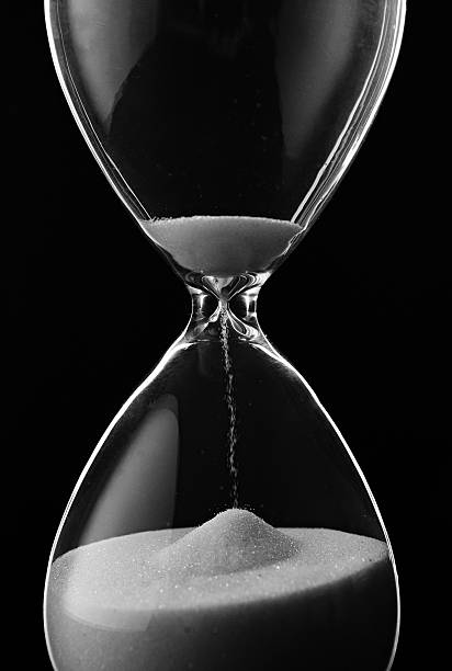 istock Sand running through the bulbs of an hourglass 516489245