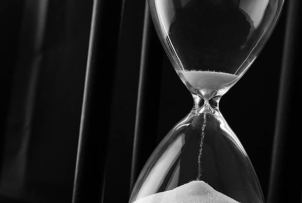 istock Sand running through the bulbs of an hourglass 516489249