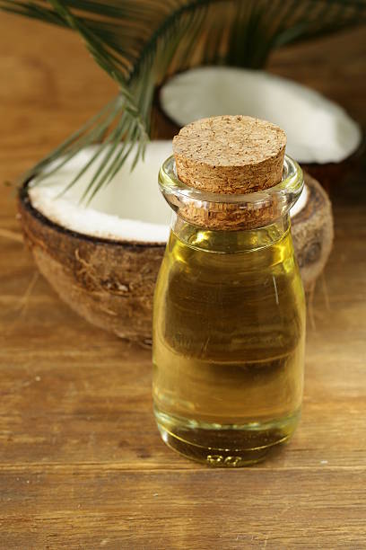 istock coconut oil in a glass bottle and fresh nuts 516490661