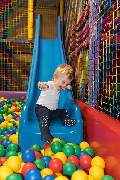 istock Little boy slides into ball pool 516492304