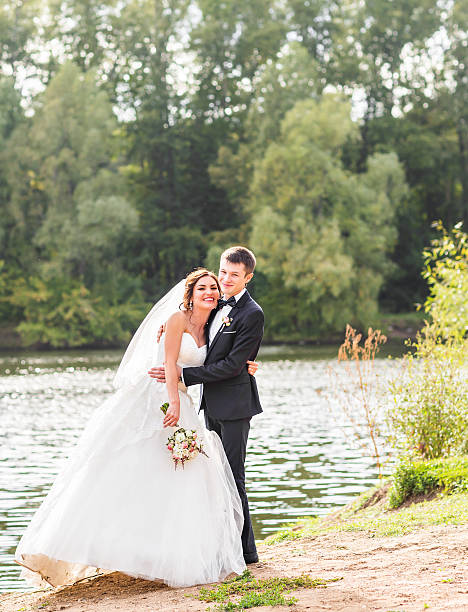 istock Wedding couple standing and hugging near lake 516493690