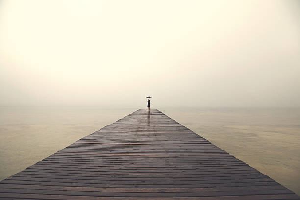 istock woman with black umbrella looking infinity in a surreal place 516494318