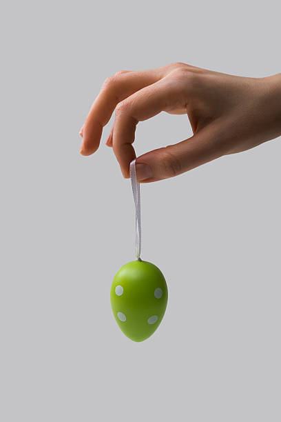 istock Female hand holding a rope with an Easter dyed egg 516494352