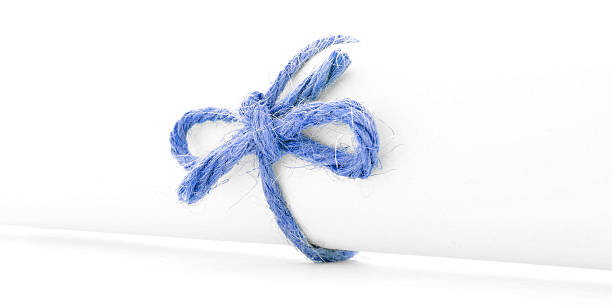 istock Handmade blue rope knot tied on white letter scroll isolated 516495628