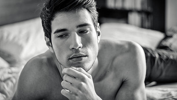 istock Shirtless sexy male model lying alone on his bed 516496050