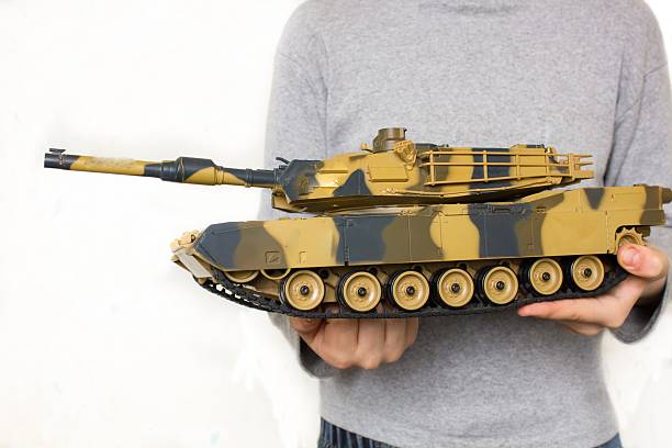 istock Child holding a big toy tank 516496260