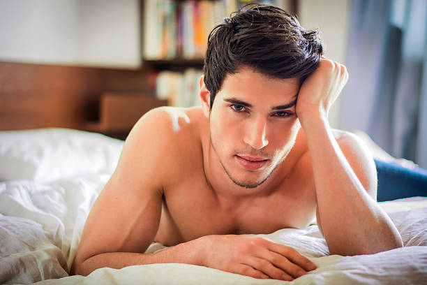 istock Shirtless sexy male model lying alone on his bed 516496388