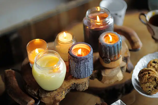 Beautiful ablaze candle on the wooden table