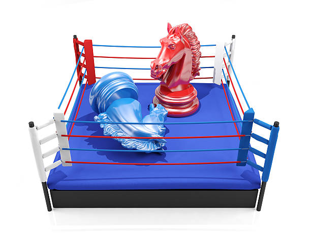istock Red chess knight wins over blue chess knight on boxing ring 516501020