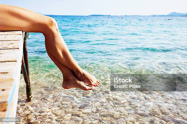Closeup Of Female Legs Over The Sea Stock Photo - Download Image Now - Beach, Naked, Sea