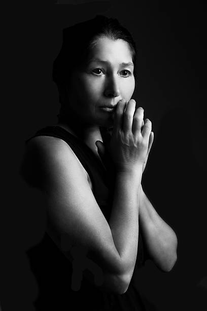 istock Woman prays on a black background 516502068