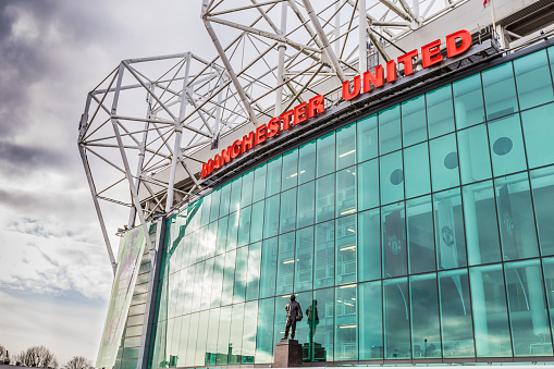 Manchester, England - February 28, 2016: The east stand of Old Trafford football stadium, home of Manchester United. With space for 75,957 spectators, Old Trafford has the second-largest capacity of any English football stadium after Wembley Stadium. 