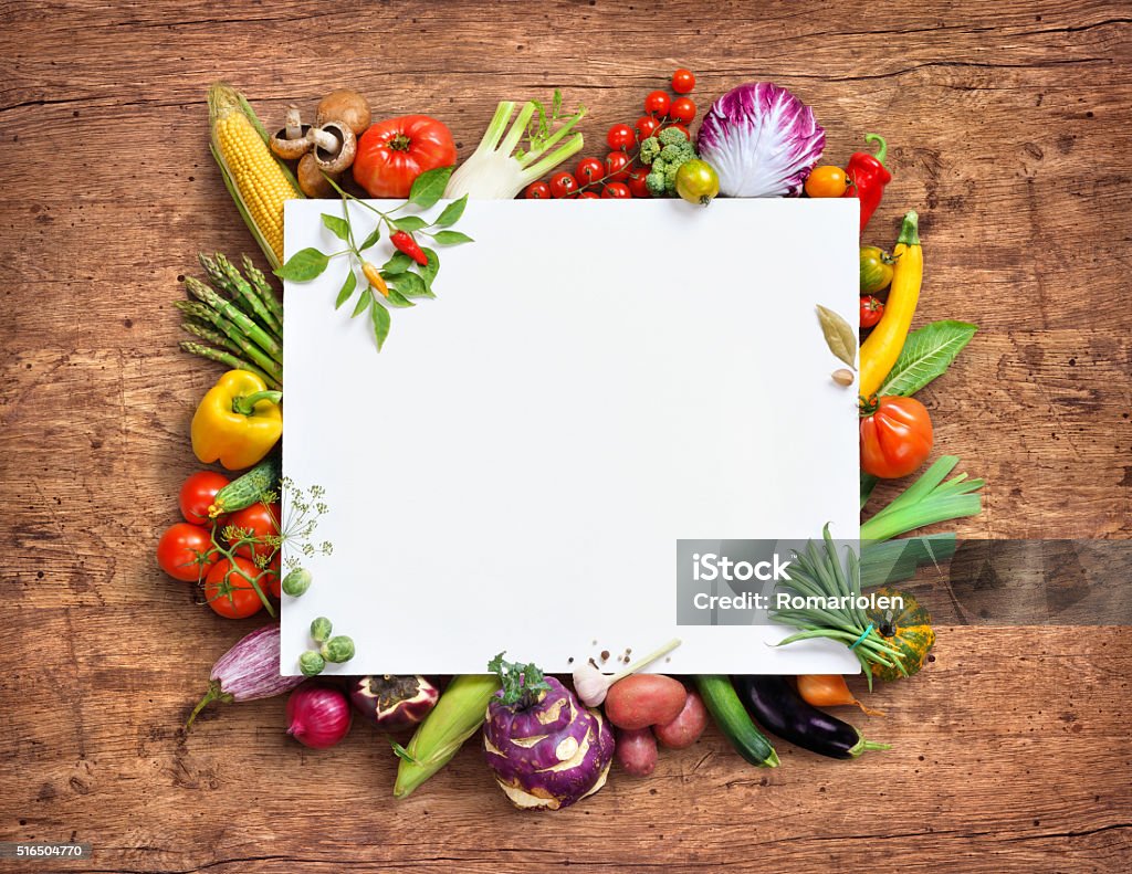 Healthy food background and Copy space. Healthy food background and Copy space. Studio photography of white paper surrounded by fresh vegetables on old wooden table Abundance Stock Photo