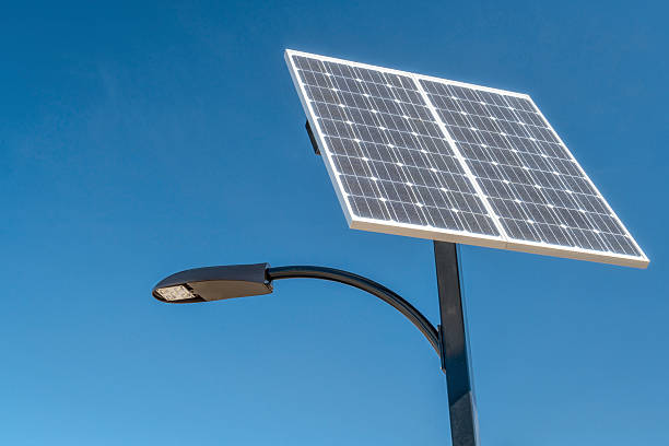 street light with solar panel street lamp with a solar panel against blue sky solar street lights stock pictures, royalty-free photos & images