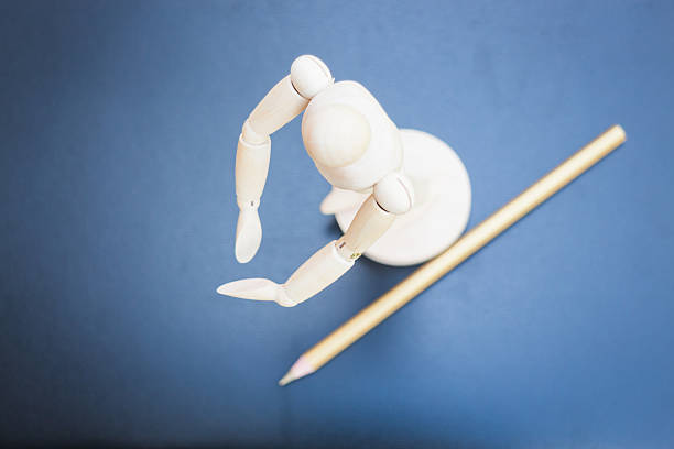 istock Wooden mannequin and pencil on dark background 516510037
