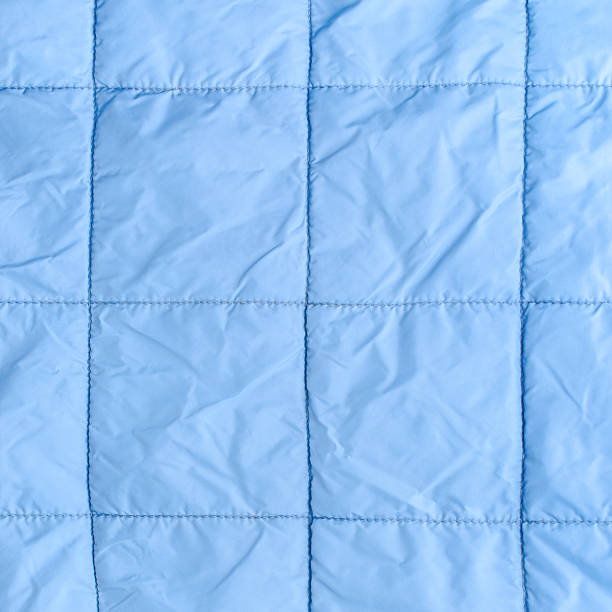 istock blue silk quilted fabric as a background, closeup 516511271