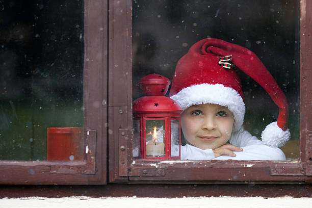 Adorable boy, looking through window, waiting for Santa