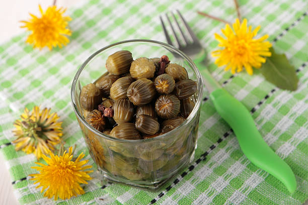 istock Marinated flower buds of dandelions in glass 516527197