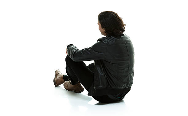 istock Rear view of man in leather jacket sitting on floor 516531779