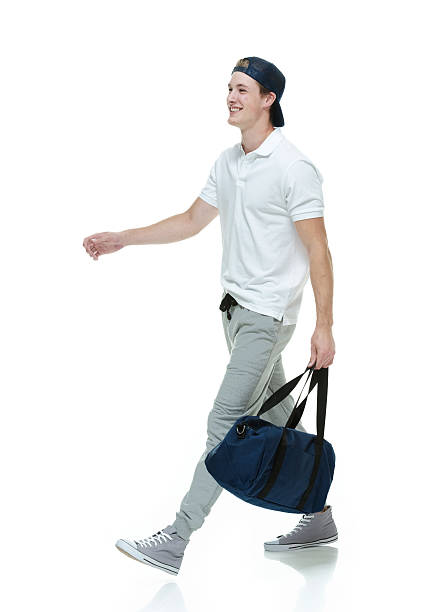 istock Cheerful man holding duffle bag & walking 516531899