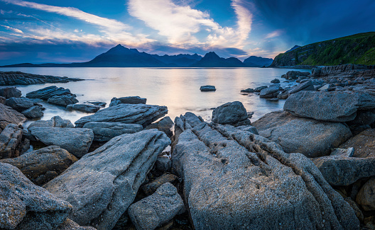 Big skies and scudding storm clouds above the dramatic mountain peaks of the Black Cuillins overlooking the rocky shores of Loch Coruisk and the picturesque pebble beach at Elgol, Isle of Skye, Scotland. ProPhoto RGB profile for maximum color fidelity and gamut.