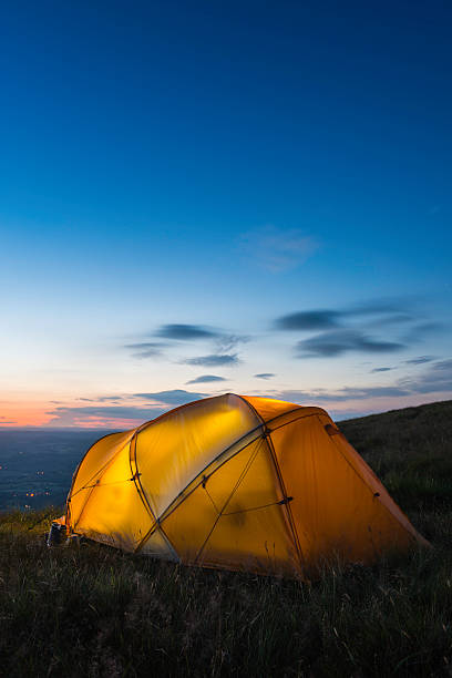 istock Warmly illuminated dome tent camped on mountain at sunset 516533763