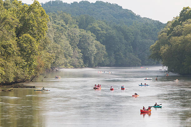 People Raft And Kayak Down River On Hot Summer Day Atlanta, GA, USA - July 25, 2015:  People raft, kayak and canoe down the  Chattahoochee River on a hot summer day on July 25, 2015 in Atlanta, GA. rafting kayak kayaking river stock pictures, royalty-free photos & images