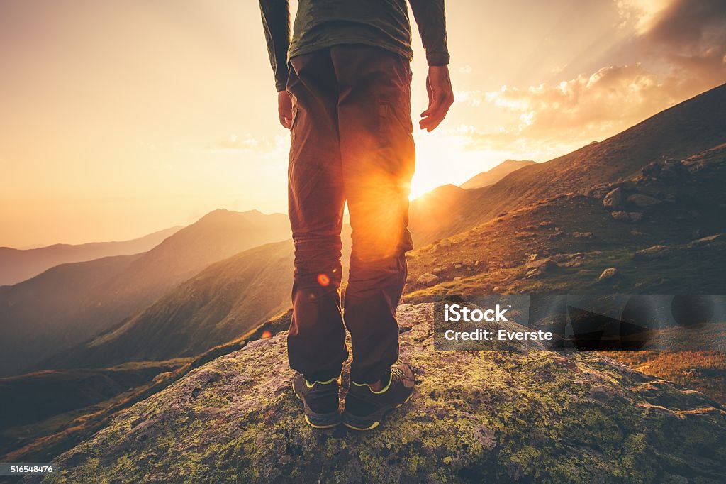 Young Man Traveler feet standing alone with sunset mountains Young Man Traveler feet standing alone with sunset mountains on background Lifestyle Travel concept outdoor Footpath Stock Photo