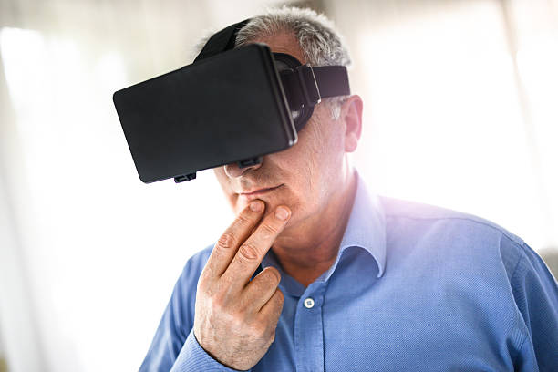 istock mature man entartains his self with virtual reality device simulator 516551222