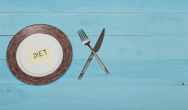istock plate with knife and fork on blue wooden table 516551546