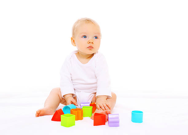 istock Baby playing with colorful toys on white background 516551924