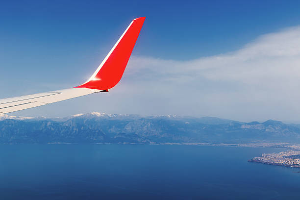 istock airplane flying above, mountain and sea view 516552022