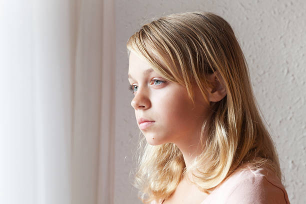 istock Caucasian girl near a window with white curtains 516552526