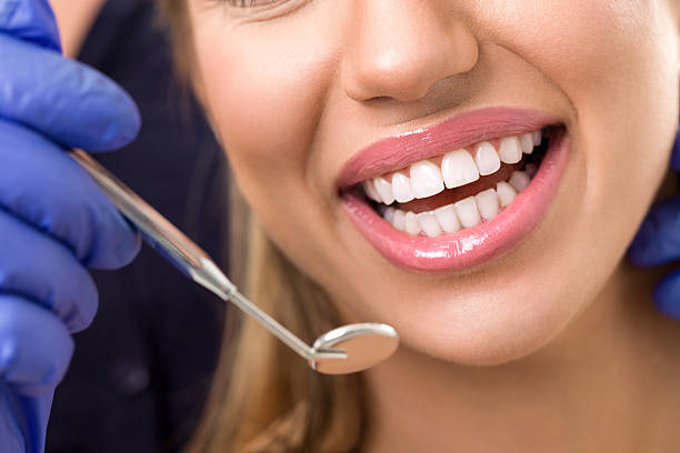 istock gorgeous healthy smile with dentist mirror 516553182
