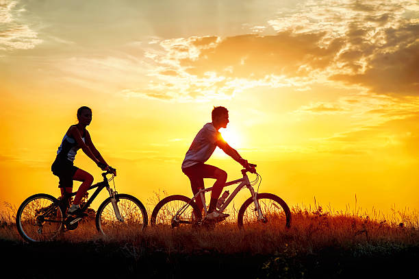 istock Couple on bicycles outdoors at sunset 516553628