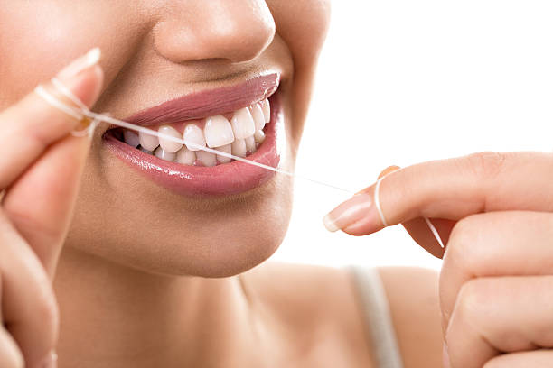Cleaning teeth with dental floss Cleaning teeth with dental floss, perfect healthy tooth dental floss stock pictures, royalty-free photos & images