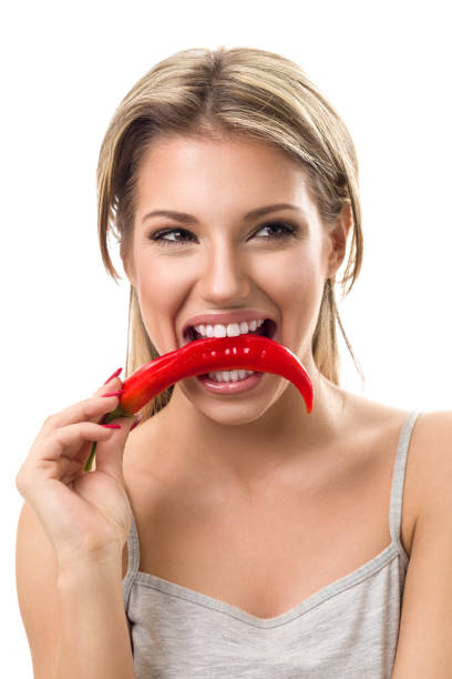 istock Funny woman biting hot pepper 516554478