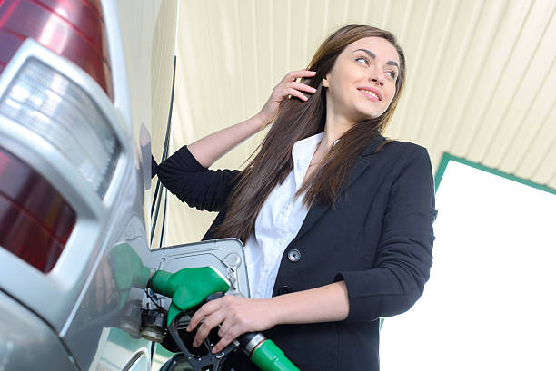 stazione di riempimento carburante - gasoline fuel pump women currency foto e immagini stock