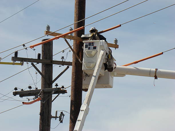 Working at the power supply system Man on a lift working on the power lines telephone pole stock pictures, royalty-free photos & images