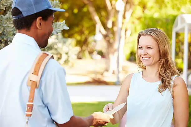 Mailman Delivering Letters To Woman Smiling