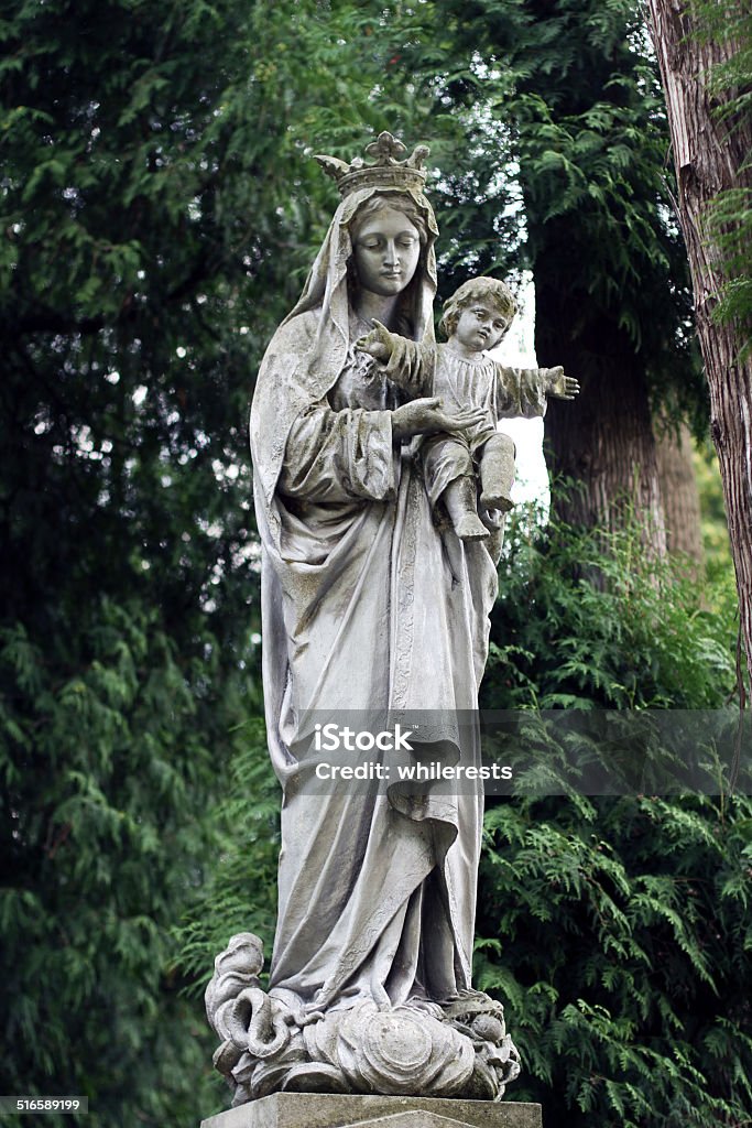 Old statue on grave in the Lychakivskyj cemetery of Lviv Old statue woman with child on grave in the Lychakivskyj cemetery of Lviv, Ukraine. Virgin Mary Stock Photo