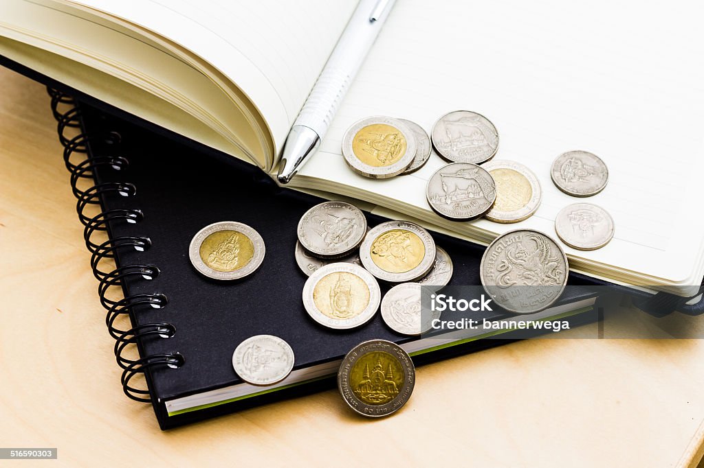 Book and coin Book and coin on the wooden table Banking Stock Photo