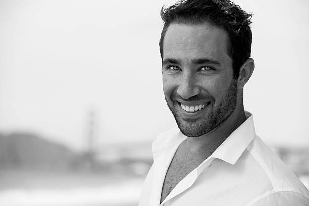 istock Portrait of handsome young man at beach 516590423