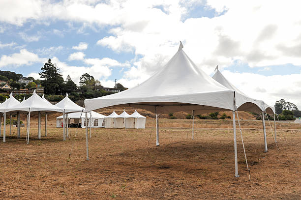 White tents in a dry field outdoors stock photo