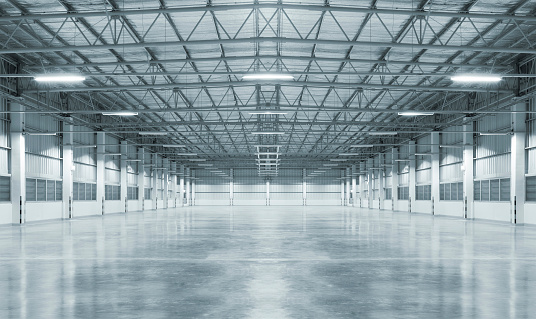Empty factory with concrete floor, night scene.