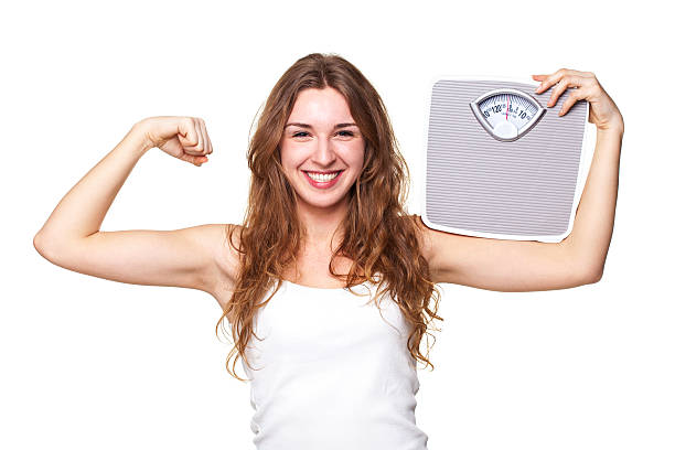 istock Young Woman Flexing With Weight Scale 516592705