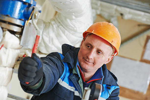 istock heating engineer repairman in boiler room 516592767