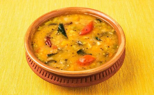 south indian vegetable sambar on yellow background