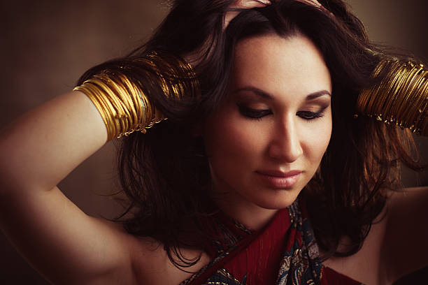 istock Indian woman with gold bracelets on hands 516595382