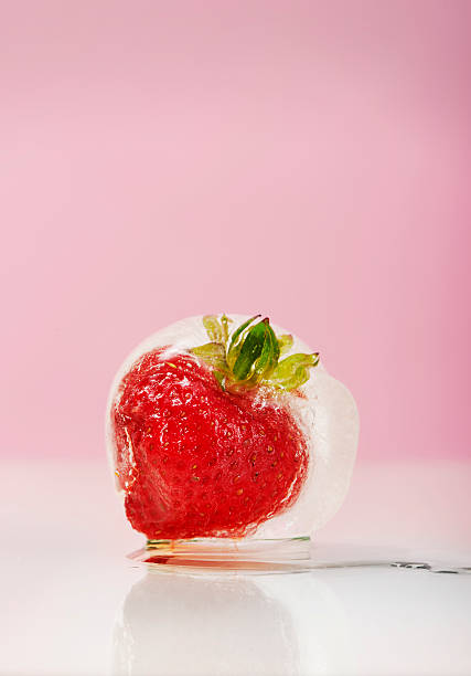 istock Heart-shaped strawberry frozen inside an ice ball 516602432